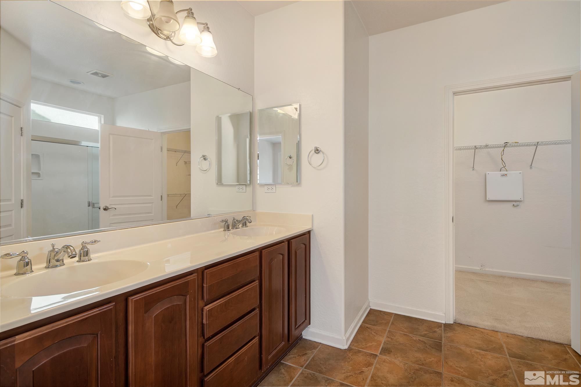 1180 Meridian Ranch Drive Reno, NV 89523 - Photo 18 of 28 a bathroom with a sink a vanity and a mirror