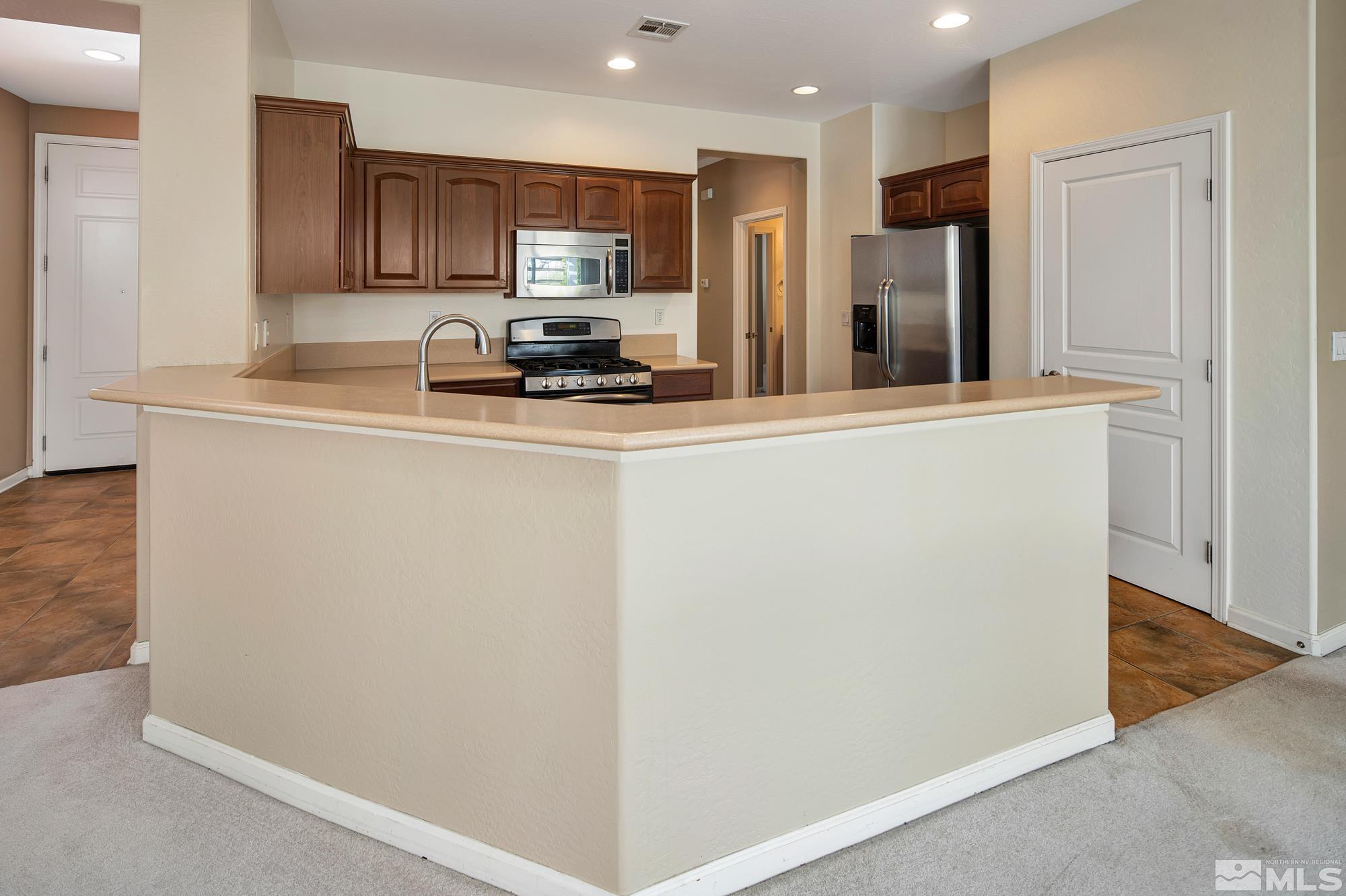 1180 Meridian Ranch Drive Reno, NV 89523 - Photo 8 of 28 a kitchen with stainless steel appliances a refrigerator and a stove top oven