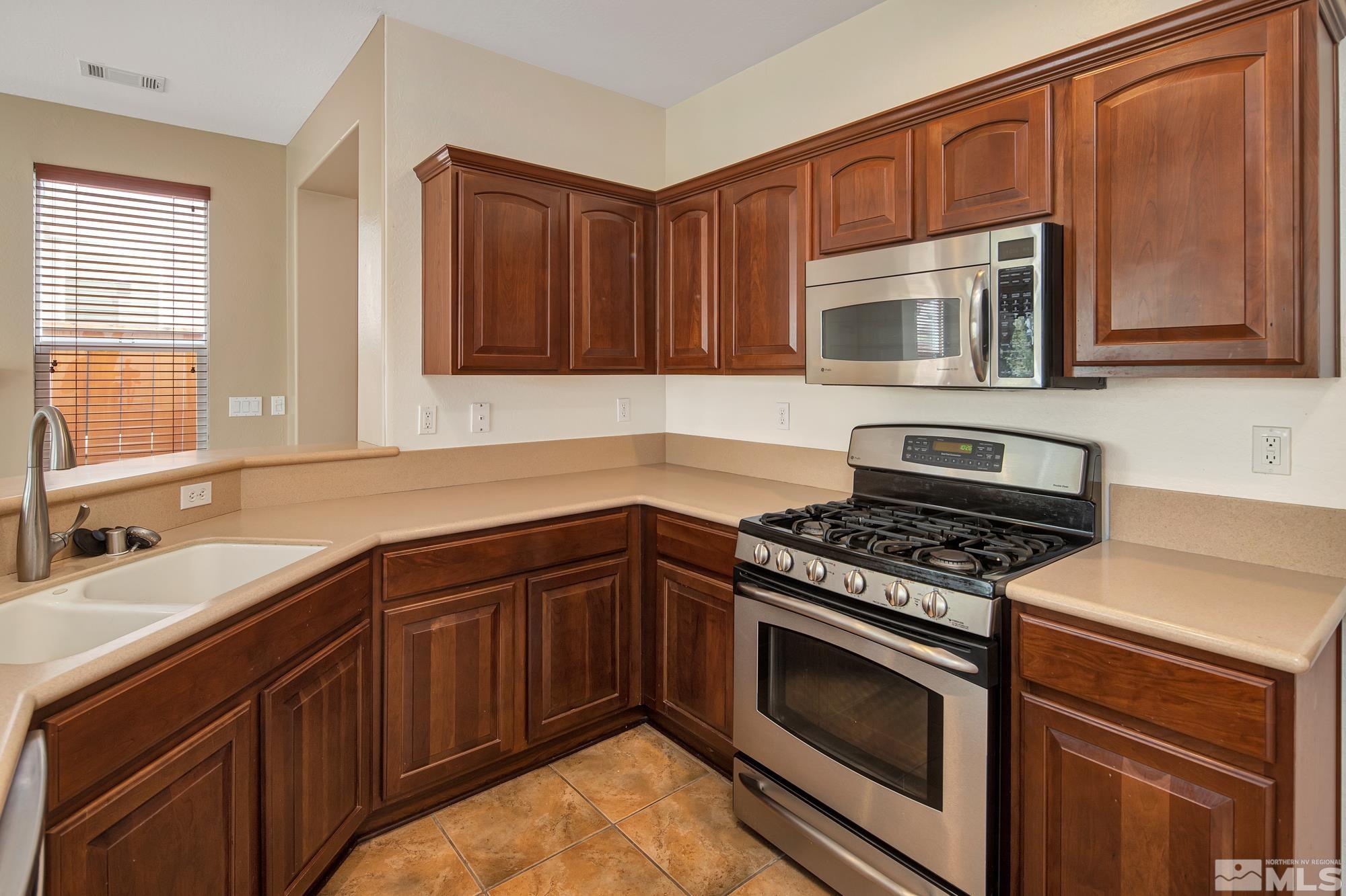 1180 Meridian Ranch Drive Reno, NV 89523 - Photo 10 of 28 a kitchen with stainless steel appliances granite countertop a stove microwave and sink