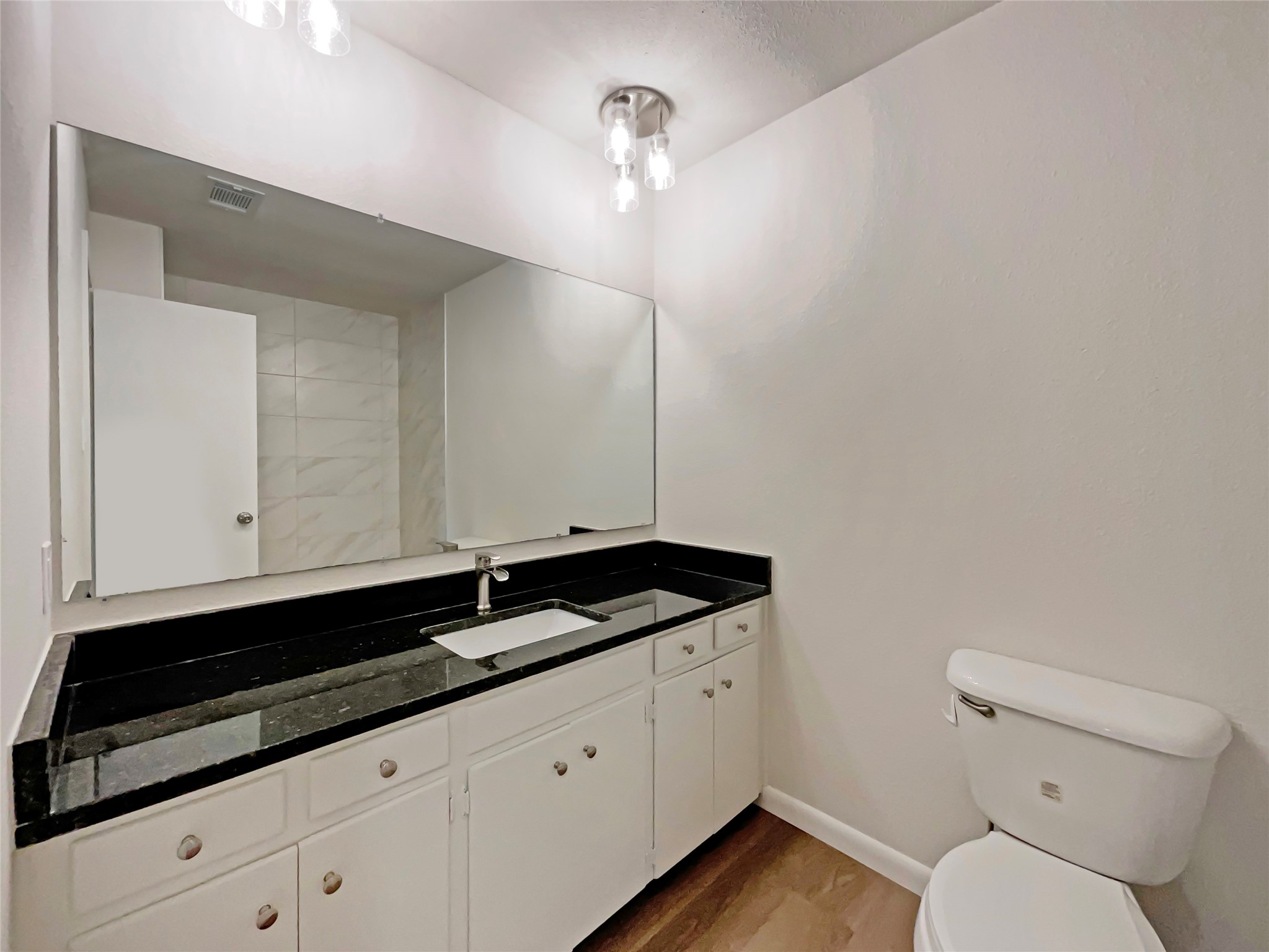 6805 Crystalbrook Drive Austin, TX 78724 - Photo 18 of 31 a bathroom with a granite countertop sink a toilet and mirror
