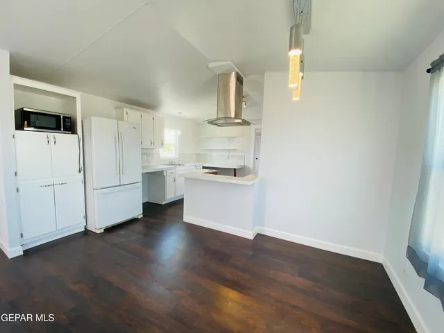 a view of an empty room with wooden floor and closet