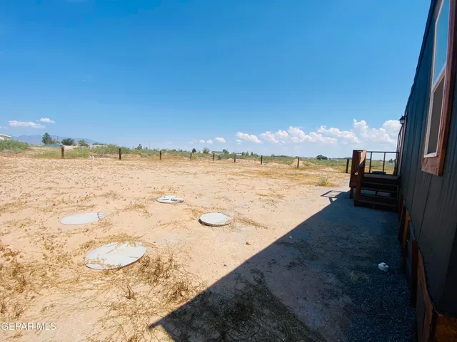 a view of a pool with table and chairs in front of it