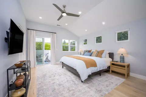 a spacious bedroom with a large bed and a flat screen tv