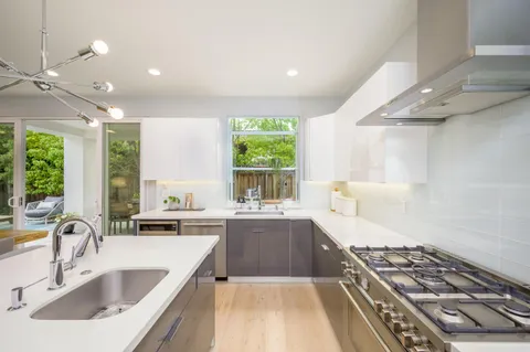 a kitchen with sink a stove and cabinets