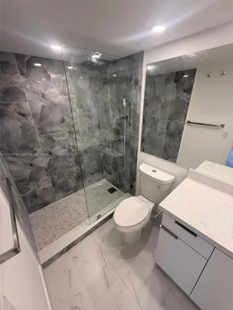 a bathroom with a shower a toilet and a sink