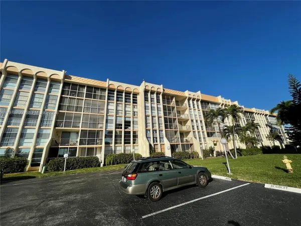 a view of building with cars parked in front of it