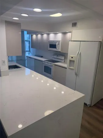 a kitchen with stainless steel appliances a refrigerator and a counter