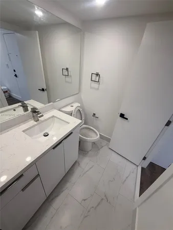 a bathroom with a sink mirror and toilet