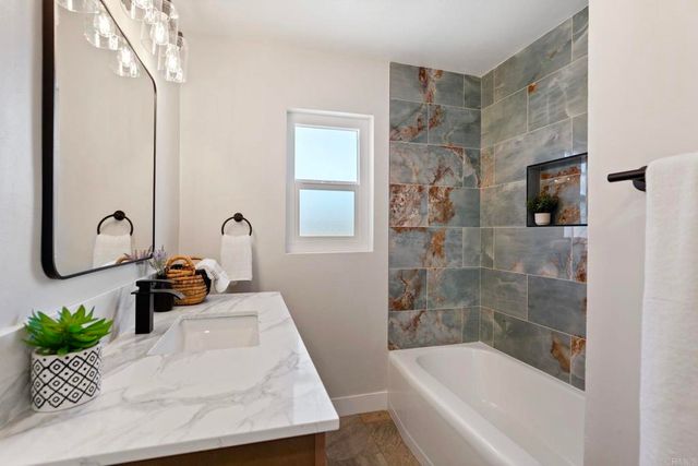 a bathroom with a tub sink and mirror