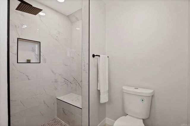 a bathroom with a toilet and a shower