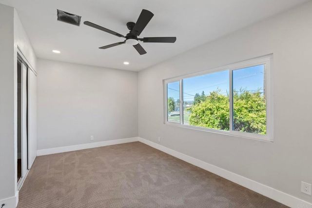 a view of a ceiling fan and a window in a room