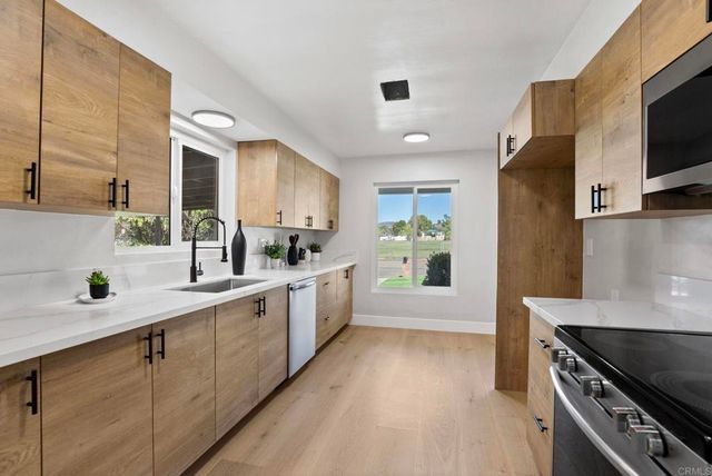 a kitchen with white cabinets and appliances