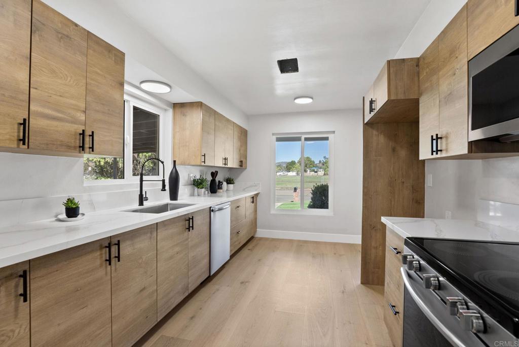 611 9th Street Ramona, CA 92065 - Photo 9 of 39 a kitchen with white cabinets and appliances