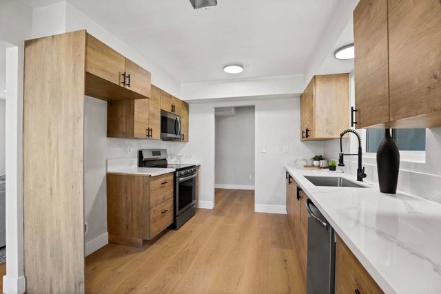 a kitchen with stainless steel appliances granite countertop a sink stove and refrigerator