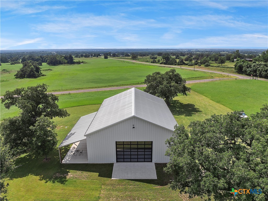 1006 County Road 280 Cameron, TX 76520 - Photo 47 of 48 a view of a lush green field with lawn chairs and large trees