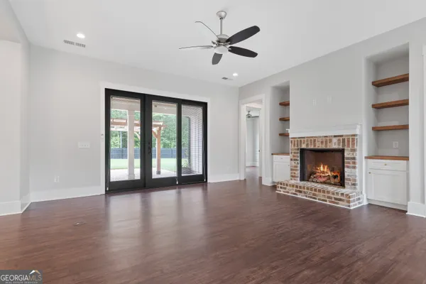 a view of an empty room with a fireplace and a window