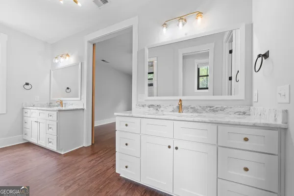a bathroom with double vanity sink a vanity and mirrors