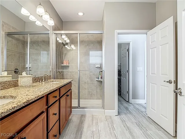 a bathroom with a granite countertop sink mirror and shower