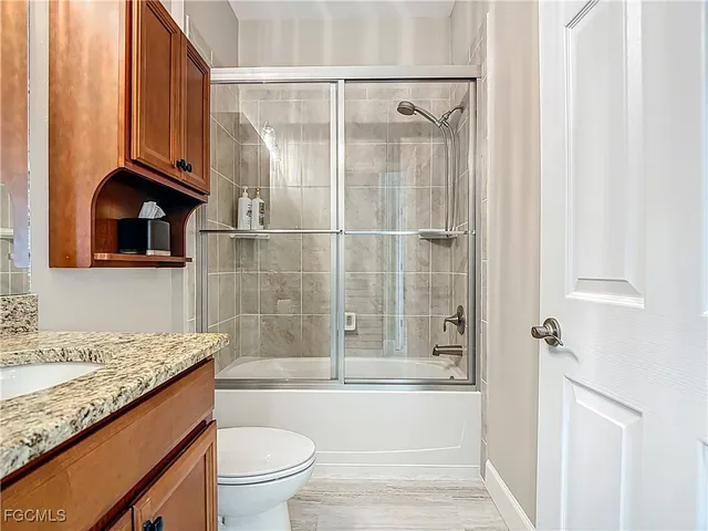 a bathroom with a granite countertop sink toilet and shower