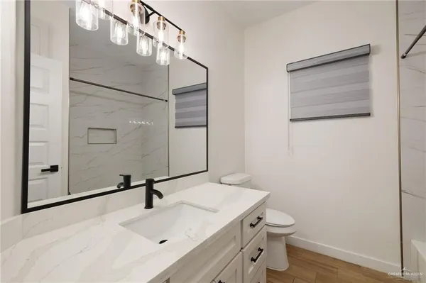 a bathroom with a sink a toilet and mirror