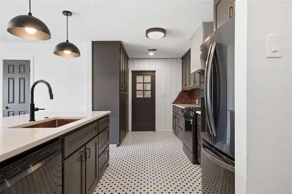 a kitchen with stainless steel appliances granite countertop a sink and a refrigerator