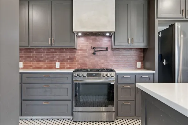 a kitchen with granite countertop a stove top oven cabinets and stainless steel appliances