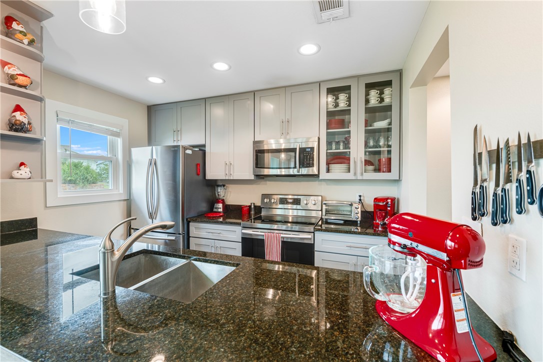 230 Cut-Off Road, Unit 101 Port Aransas, TX 78373 - Photo 11 of 30 a kitchen with stainless steel appliances granite countertop a sink and a refrigerator