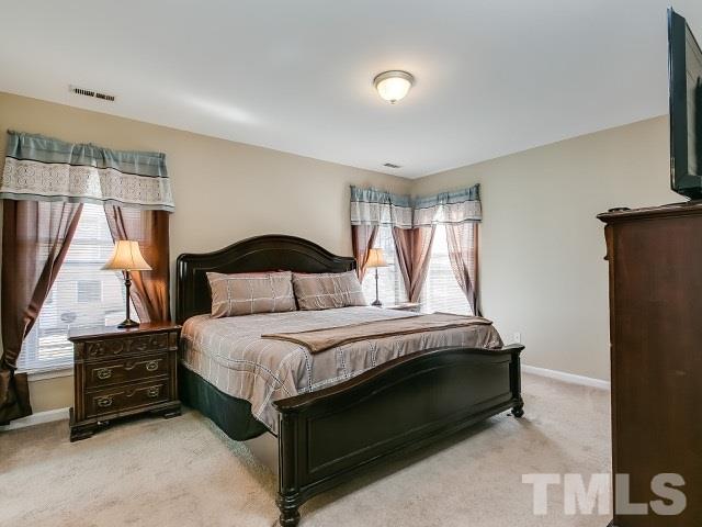 5709 Edgebury Road Raleigh, NC 27613 - Photo 13 of 20 a bedroom with a bed table and window