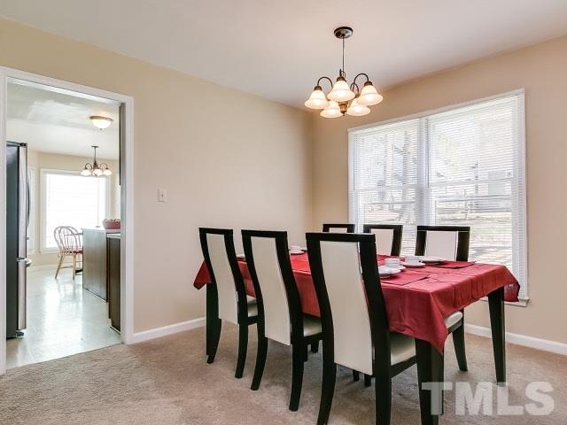 5709 Edgebury Road Raleigh, NC 27613 - Photo 4 of 20 a view of a dining room with furniture and a chandelier