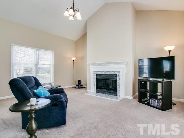 5709 Edgebury Road Raleigh, NC 27613 - Photo 5 of 20 a living room with furniture a flat screen tv and a fireplace
