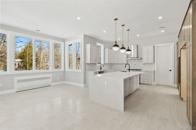 a large white kitchen with a large window appliances and furniture