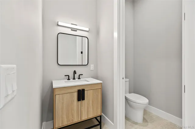 a bathroom with a toilet sink vanity and mirror