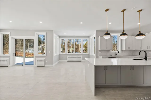 a large kitchen with kitchen island a sink a counter space and a wooden floor