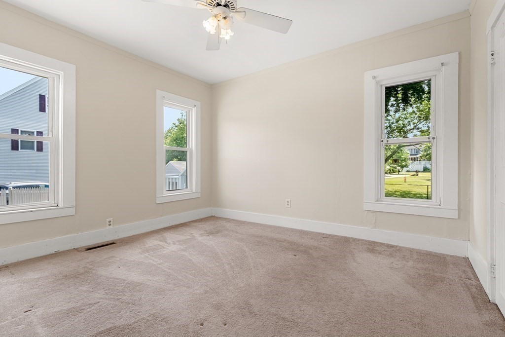 70 Beach Road Salisbury, MA 01952 - Photo 5 of 29 an empty room with windows and chandelier fan