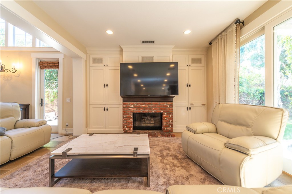 4 Whispering Pine Irvine, CA 92620 - Photo 5 of 13 a living room with furniture a fireplace and a flat screen tv