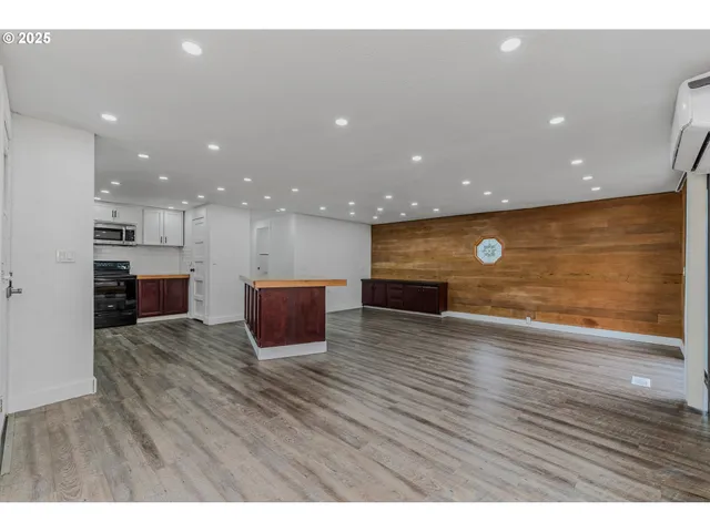 a view of kitchen with kitchen island granite countertop a stove top oven and a sink