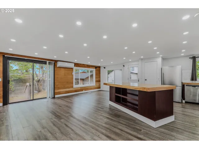 a view of kitchen with stainless steel appliances granite countertop counter top and living room