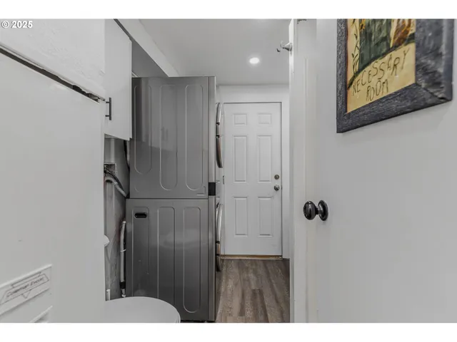 a view of a hallway with wooden floor and cabinet