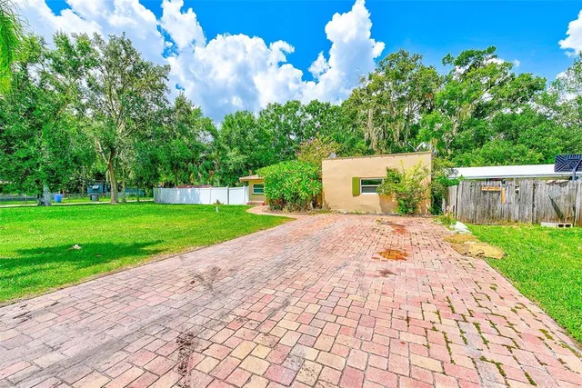 a view of yard with small fountain plants and large tree