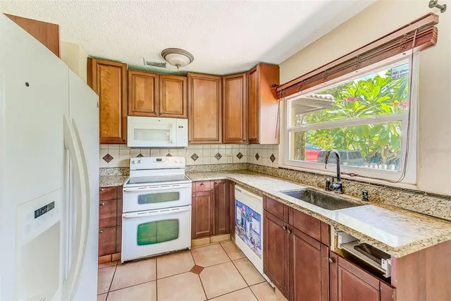 a kitchen with granite countertop a sink stainless steel appliances and cabinets