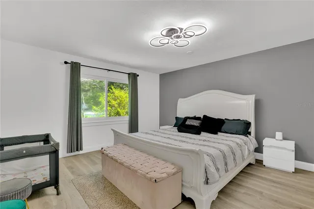 a bedroom with a bed and wooden floor