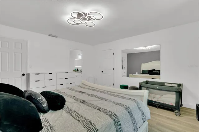 a bedroom with a large bed and a chandelier