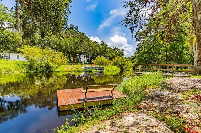 a view of a house with a big yard and large trees