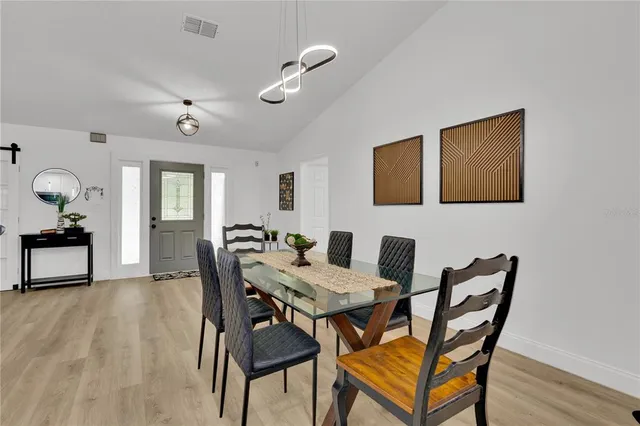 a kitchen with stainless steel appliances kitchen island granite countertop a table chairs and a refrigerator