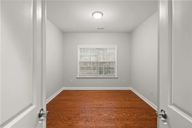 an empty room with a window and a fan