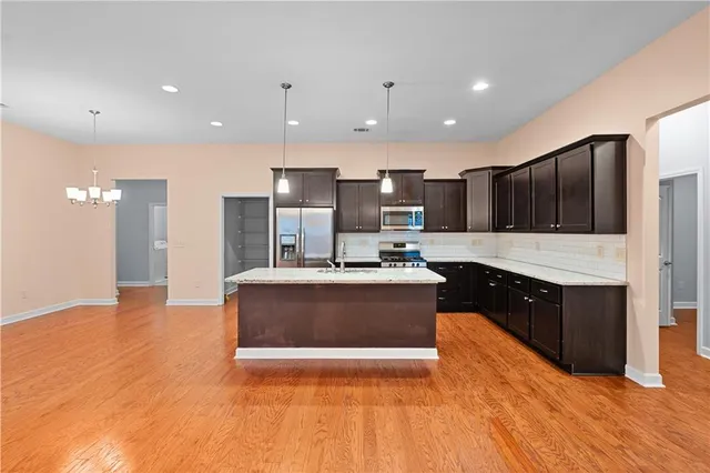 a large kitchen with stainless steel appliances kitchen island granite countertop a sink counter space and cabinets