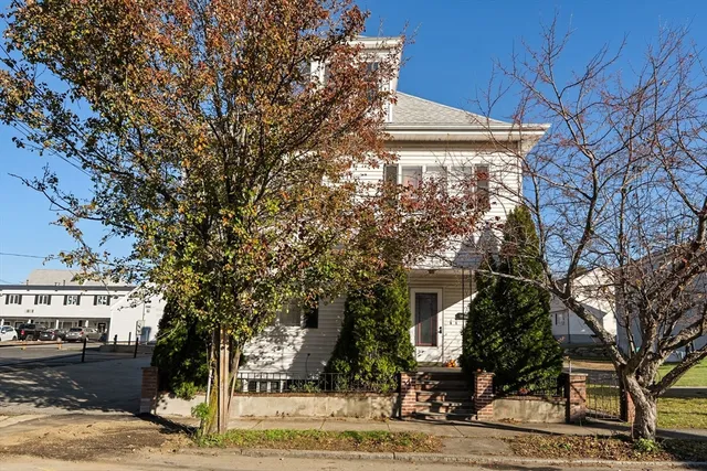 a front view of a building with trees