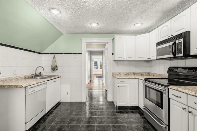 a kitchen with stainless steel appliances granite countertop a sink and stove top oven