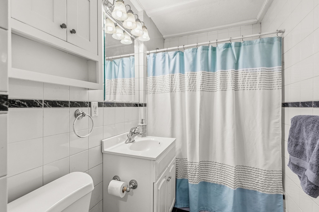 4 Elm Street, Unit 3 Peabody, MA 01960 - Photo 21 of 24 a bathroom with a sink a toilet and shower curtain