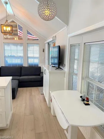 a living room with a couch a flat screen tv and a large window